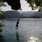 Boys jumping from a rope swing at Lake Bled, Slovenia